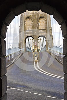 Open-air stone arch view out onto the Menai Suspension Bridge & A5 traffic road, Gwynedd, North Wales