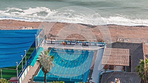 Open air swimming pool on a beach in Miraflores district of Lima aerial timelapse. photo