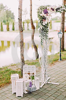 Open air wedding composition. The part of the flower wedding arch and vintage boxes with candles. photo