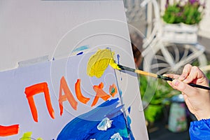 Open air workshop.  Easter Holiday festival in Moscow. A child paintis a picture for Easter. Easter inscription in Russian