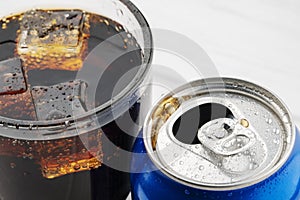 Open aluminum can and glass of cola isolated on white