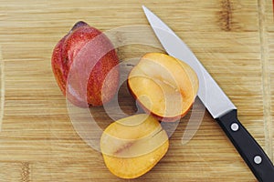 Open Amigo Pluot Next to a Whole Amigo Pluot with Knife