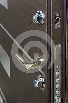 Open armored door. Door lock, Dark brown door closeup. Modern interior design, door handle. New house concept. Real estate.