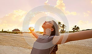 Open arms girl at sunset caribbean beach