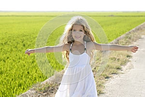 Open arms little happy girl in rice field