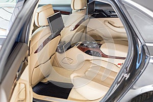 Open back door of business class car. Rear seat of modern luxury vehicle. Interior of limousine with entertainment