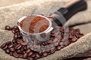 An open bag of coffee beans. Holder filter with ground coffee for coffee machines. Close up.