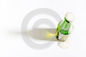 Open beer bottle with foam on white background with border