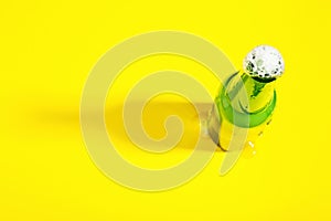 Open beer bottle with foam on yellow background with border