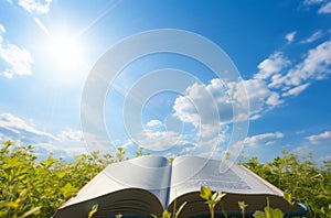 Open bible against blue sky with clouds