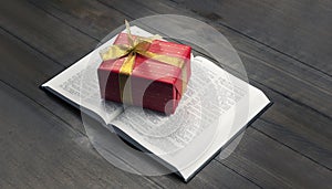 Open Bible. Book. Gift in a red package with a gold bow. On a wooden table.