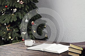 Open Bible. A cup of coffee. Office businessman. Christmas. Christmas tree. Desktop, Workplace.