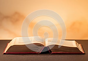 open bible. opened book laying on a wood table.