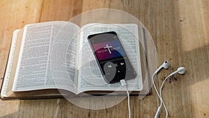 open bible with phone and headphones,Concept listen the words of God.Bible, phone and earphones on wood table, top view