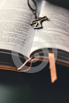 An open bible is placed on a black surface table.