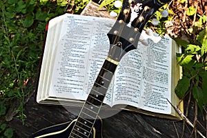 Open Bible with propped up mandolin and the sun shining on it.