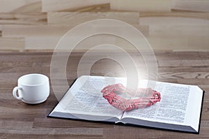 Open Bible. On the table. Heart love. A cup of coffee.