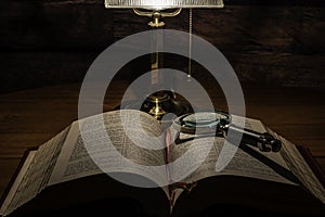 Open bible on table with magnifying glass