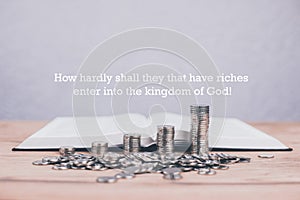 An open Bible on the table. Prayer. Stacks of coins in ascending order. Wealth. Investment and accumulation.