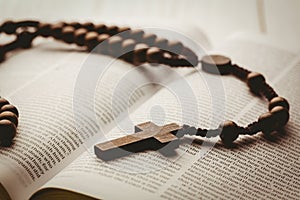 Open bible and wooden rosary beads