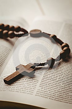 Open bible and wooden rosary beads