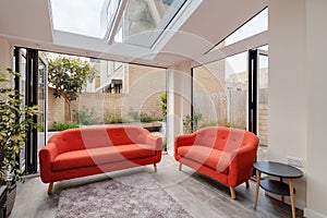 Open bifold doors with orange sofas