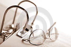 Open binder and glasses over document