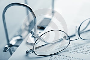 Open binder and glasses over document