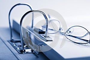 Open binder and glasses over document
