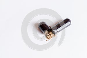 Open black capsule of medication