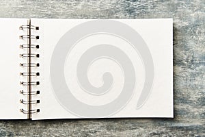 Open blank note book on rustic wooden background.