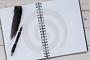 Open blank notebook,pen and feather