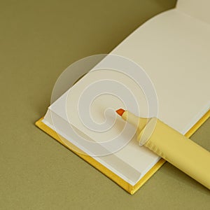 Open blank notebook and yellow highlighter on desk