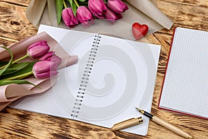 Open blank notepad and bouquet of pink tulip flowers
