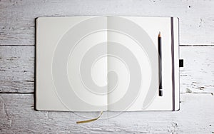 Open blank notepad with empty pages with a pencil