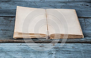 open blank pages of old book on wood background