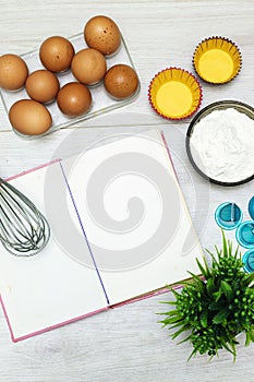 Open blank recipe book, eggs and flour