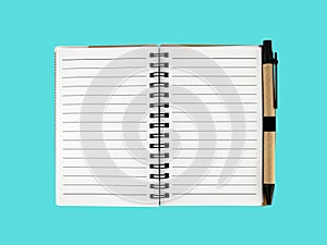 open blank small notebook with tan recycled paper ballpoint pen isolated on blue background