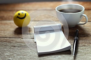 Open a blank white notebook, pen and cup of coffee