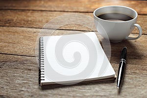 Open a blank white notebook, pen and cup of coffee