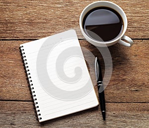 Open a blank white notebook, pen and cup of coffee