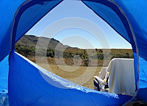 Open blue camping tent, where you can contemplate the green horizon