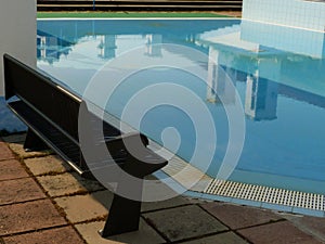 Open blue kids` swimming pool with benches and awnings