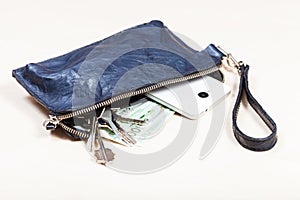 Handbag with phone, keys and euro notes on table