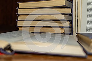 An open book on the background of a stack of books. Reading a book. close-up of an old book open on the library desk selective