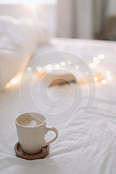 Open book on bedsheets and a cup of coffee. Good morning. Breakfast in bed. flat lay