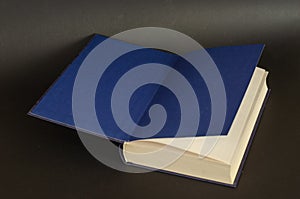 Open book on a black background. Textbook with blue endpapers. H photo