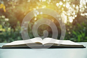 Open book. Book open on old wooden table on nature background