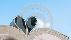 Open book with curled leaves in the shape of a heart