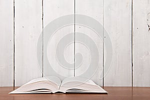 Open book on the desk over wooden background